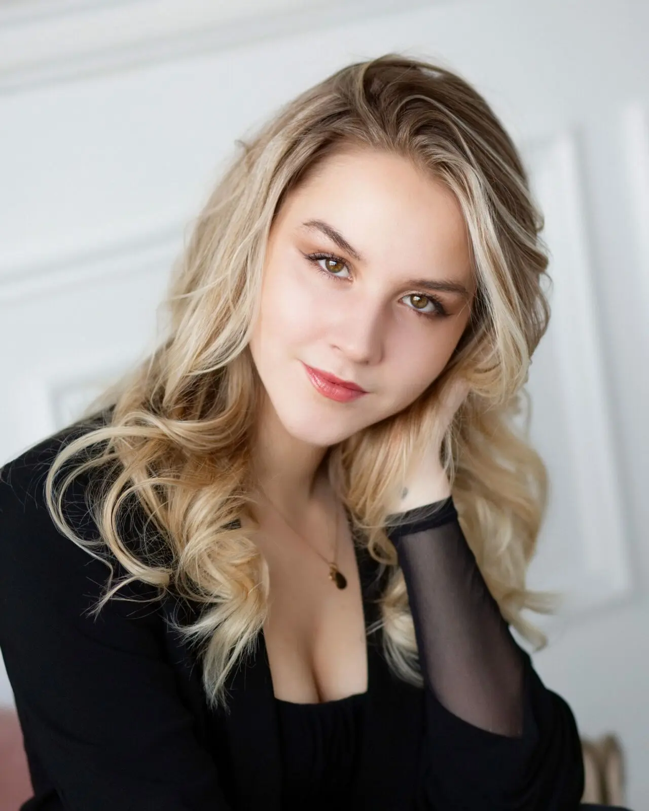 Boudoir Studio Assistant Katrina pictured, blonde girl in a black blouse against a white background