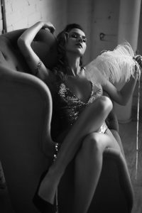 black and white boudoir photography, tattoos, young woman, sparkly body suit and white feather