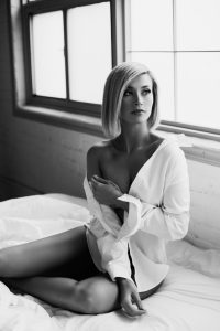 Black and white classy bridal boudoir photography, blonde woman covering herself in white shirt