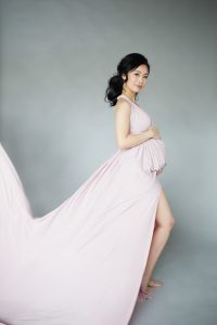 Elegant maternity photography Toronto, Pregnant woman, long pink dress flying in the wind, beautiful brunette asian woman
