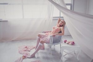 Lady in a Toronto boudoir photography studio, wearing a pink corset and tutu skirt.